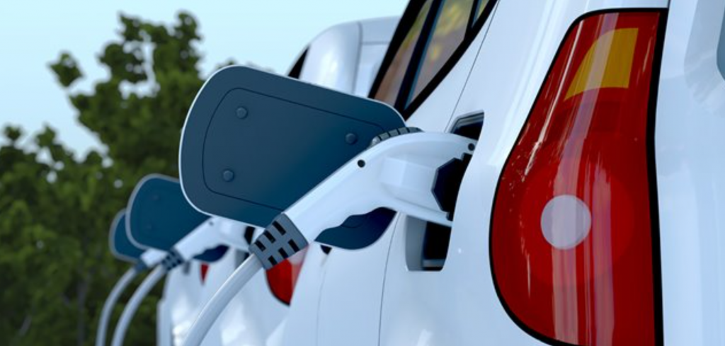 A white EV is plugged into a charger